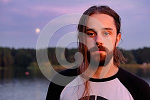 Portrait of handsome bearded young man with long hair