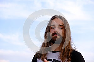 Portrait of handsome bearded young man with long hair