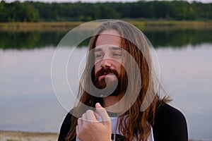 Portrait of handsome bearded young man with long hair