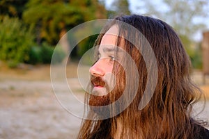 Portrait of handsome bearded young man with long hair