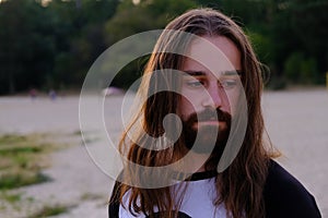 Portrait of handsome bearded young man with long hair