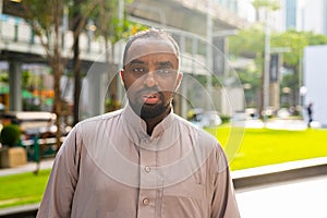 Portrait of handsome black man in city wearing traditional clothes