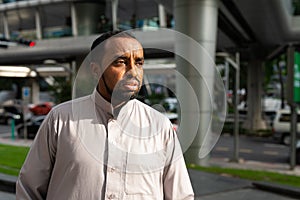 Portrait of handsome black man in city wearing traditional clothes