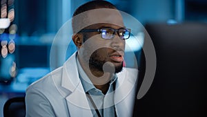 Portrait of Handsome Black Man Wearing Glasses Working Confidently on a Computer. Young Intelligent