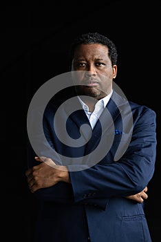 Portrait of handsome black man wearing suit with arms crossed