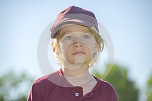 Portrait of a handsome blonde caucasian boy in baseball uniform