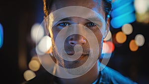 Portrait of Handsome Blonde Man Smiling and Looking at Camera, Standing in Night City with Bokeh