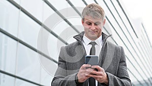 Portrait of handsome business man using smartphone and drinking