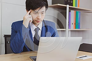 Portrait handsome businessman. Attractive handsome young business man is thinking and working work on laptop computer on desk
