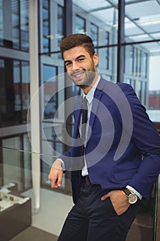 Portrait of handsome businessman standing in corridor