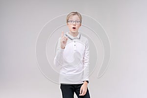 Portrait handsome caucasian boy in glasses who just has an idea points his