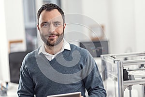 Portrait of handsome cheerful engineer posing in his office