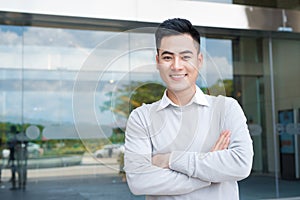 Portrait of an handsome confident asian man outside buidling. photo