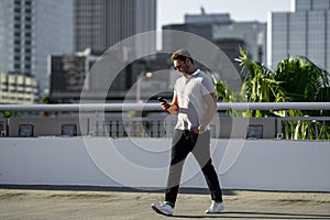 Portrait of handsome confident man chatting on phone in city. Guy talking on phone in american city. Sexy man dressed in