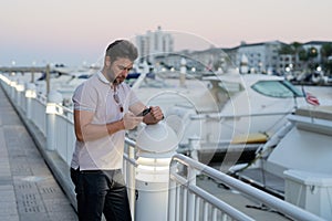 Portrait of handsome confident stylish man chatting on phone in big city. Sexy man in casual clothes talking on phone on