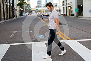 Portrait of handsome confident stylish man chatting on phone in big city. Sexy man in casual clothes talking on phone on