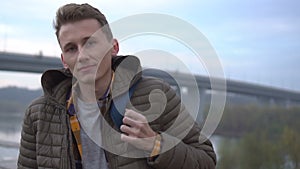 Portrait of handsome cute caucasian man outdoor. Close-up. Serious young man looking at camera