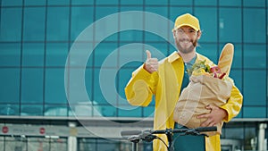 Portrait of Handsome Delivery Person in Yellow Uniform with bike.