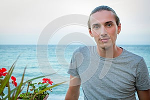 Portrait of handsome fashion man model posing on blue sea background.