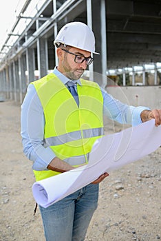 Portrait of handsome foreman construction worker on industrial building industry construction site