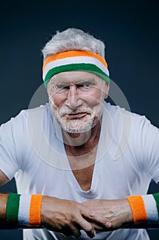 Portrait of a handsome gray haired senior man with sports headband. Sport and health care concept