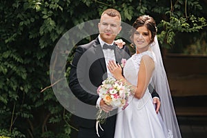 Portrait of handsome groom and charming bride. Romantic atmophere on the wedding