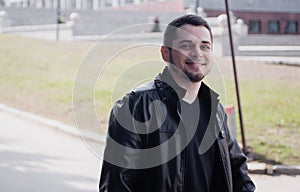 Portrait of a handsome guy who is sitting in the street