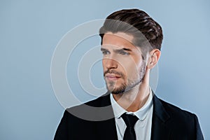 Portrait of handsome harsh man with bristle in black suit