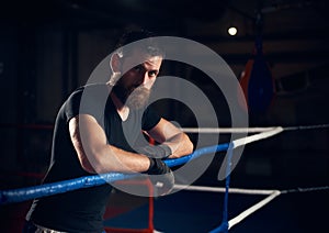 Portrait of handsome kick boxer in the ring at health club