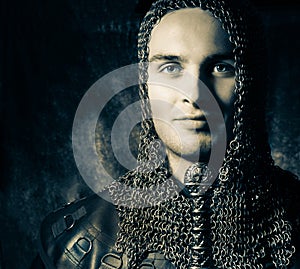 Portrait of handsome knight in suit of armour looking at camera