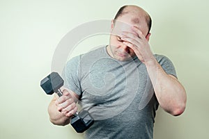 Portrait of a handsome male boxer warming up in the gym. boxer and yellow dumbbell in hand. the man strikes.