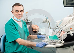 Portrait of handsome male dentist with dental devices in the dental clinic