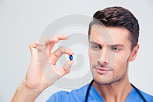 Portrait of a handsome male doctor holding pill