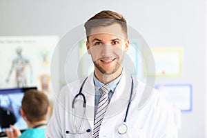 Portrait of handsome male doctor in modern clinic