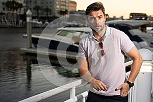 Portrait of handsome male model outdoor. Stylish man dressed in polo. Fashion male posing on the street background