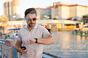 Portrait of handsome male model outdoor. Stylish man dressed in polo. Fashion male posing on the street background