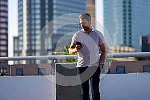 Portrait of handsome male model outdoor. Stylish man dressed in polo. Fashion male posing on the street background