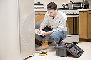 Male technician writing a work report