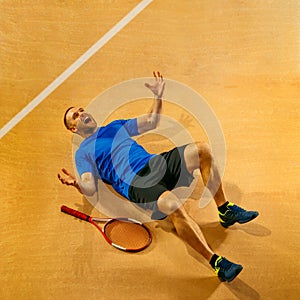 Portrait of a handsome male tennis player celebrating his success at court