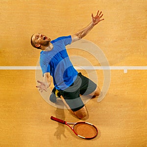 Portrait of a handsome male tennis player celebrating his success at court