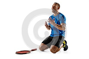 Portrait of a handsome male tennis player celebrating his success isolated on a white background