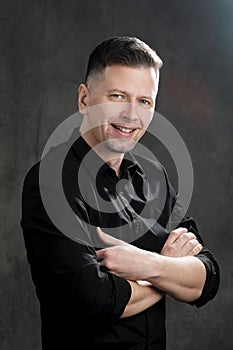 Portrait of a handsome man 40 years old on a dark artistic background close-up. Brunette, with gray hair, black beard