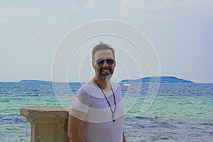 portrait of handsome man on the beach smiling at camera