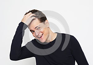 portrait of handsome man in black sweater touching his hair over white background