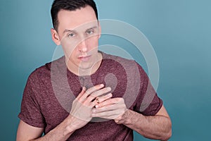 Portrait of handsome man on a dark who tries to remove an engagement ring from his finger. concept of infidelity