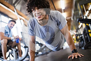 Portrait of a handsome man doing push ups exercise in gym