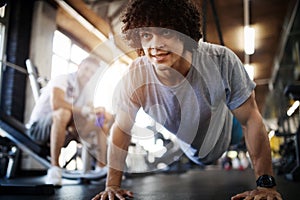 Portrait of a handsome man doing push ups exercise in gym