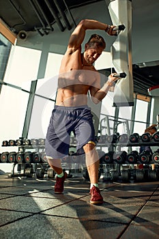 Portrait of a handsome man doing push ups exercise with modern weight equipment in fitness gym.