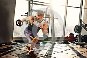 Portrait of a handsome man doing push ups exercise with modern weight equipment in fitness gym.