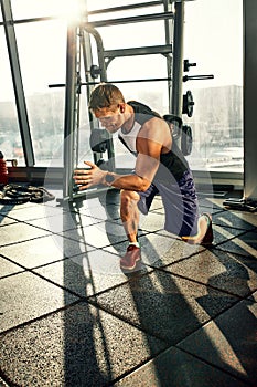 Portrait of a handsome man doing push ups exercise with modern weight equipment in fitness gym.